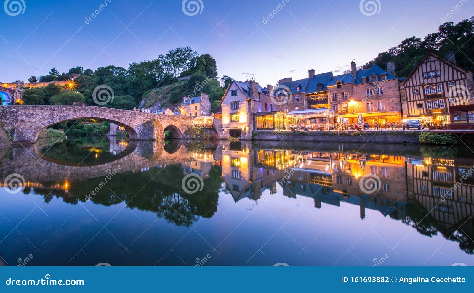 dinan and medieaval stone houses reflecting in rance river at dusk in summer in bretagne, cotes d`armor, france