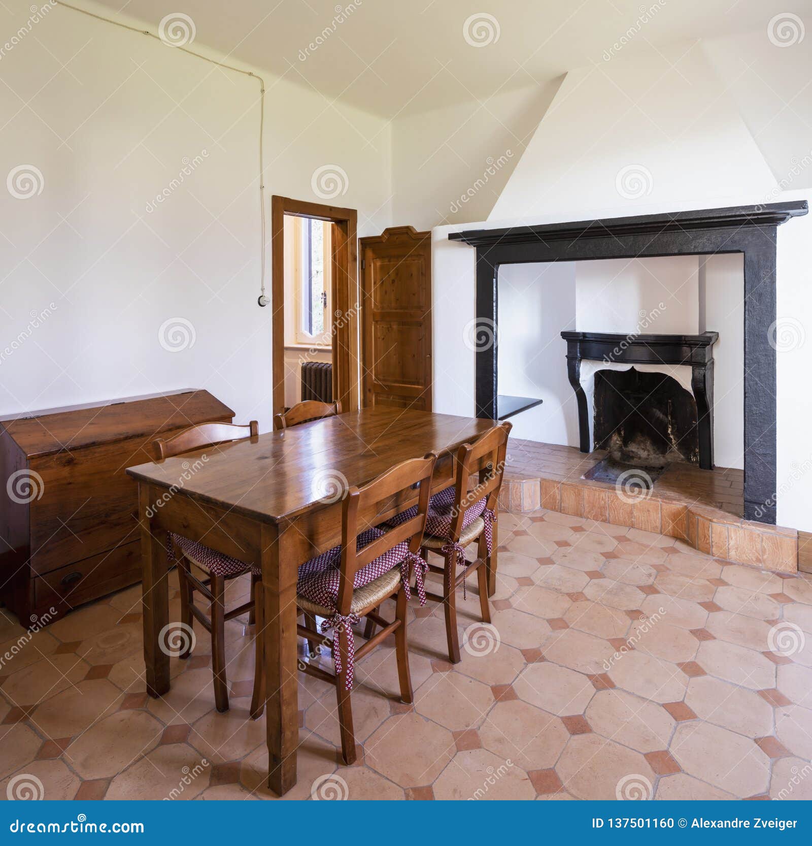 Dining Room with Table, Wooden Chairs and a Stone Fireplace Stock Photo