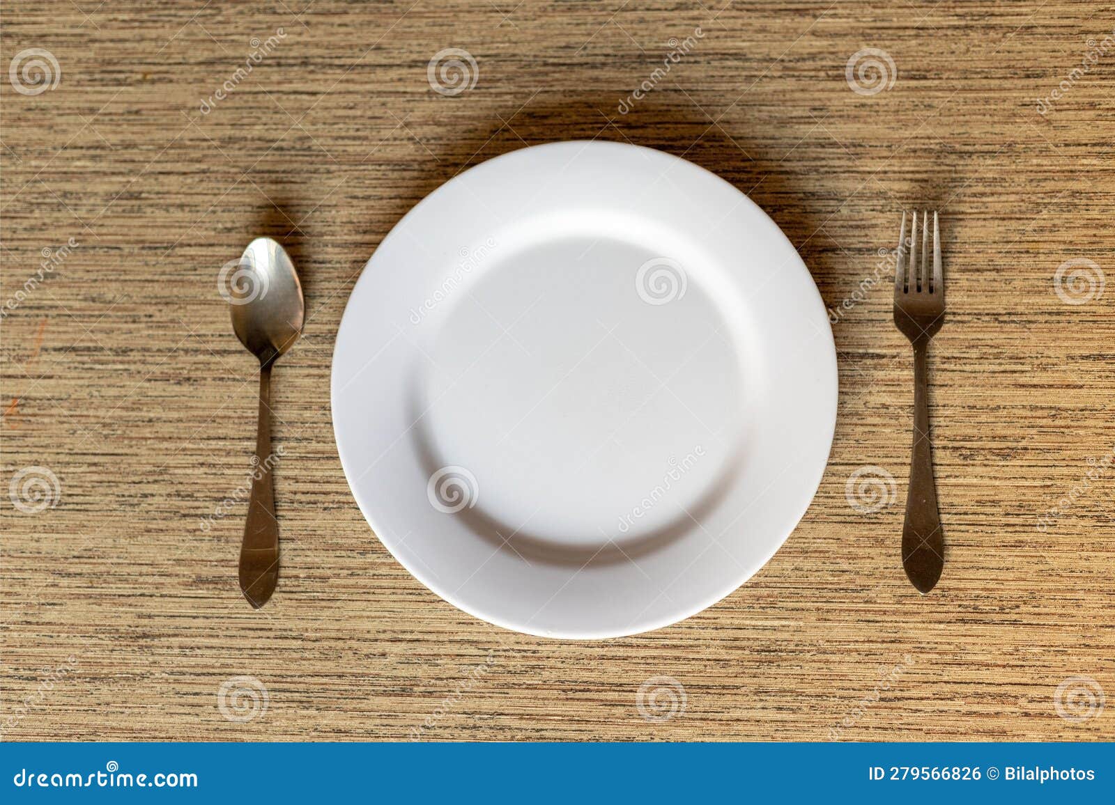 Dinner Plate with Spoon and Fork on a Table Flat Lay Top View Stock