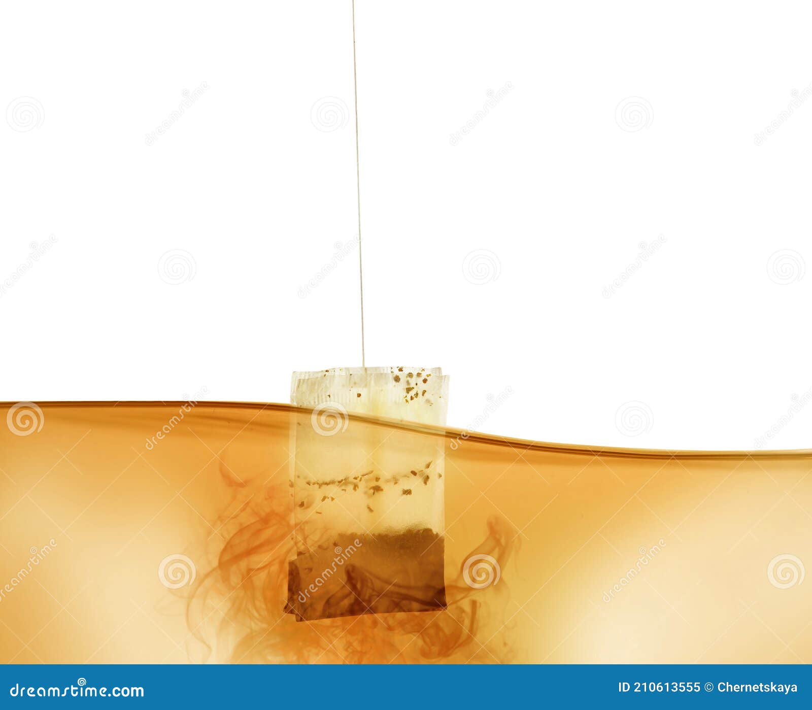 Dipping of Tea Bag into Hot Water Against White Background Stock Image