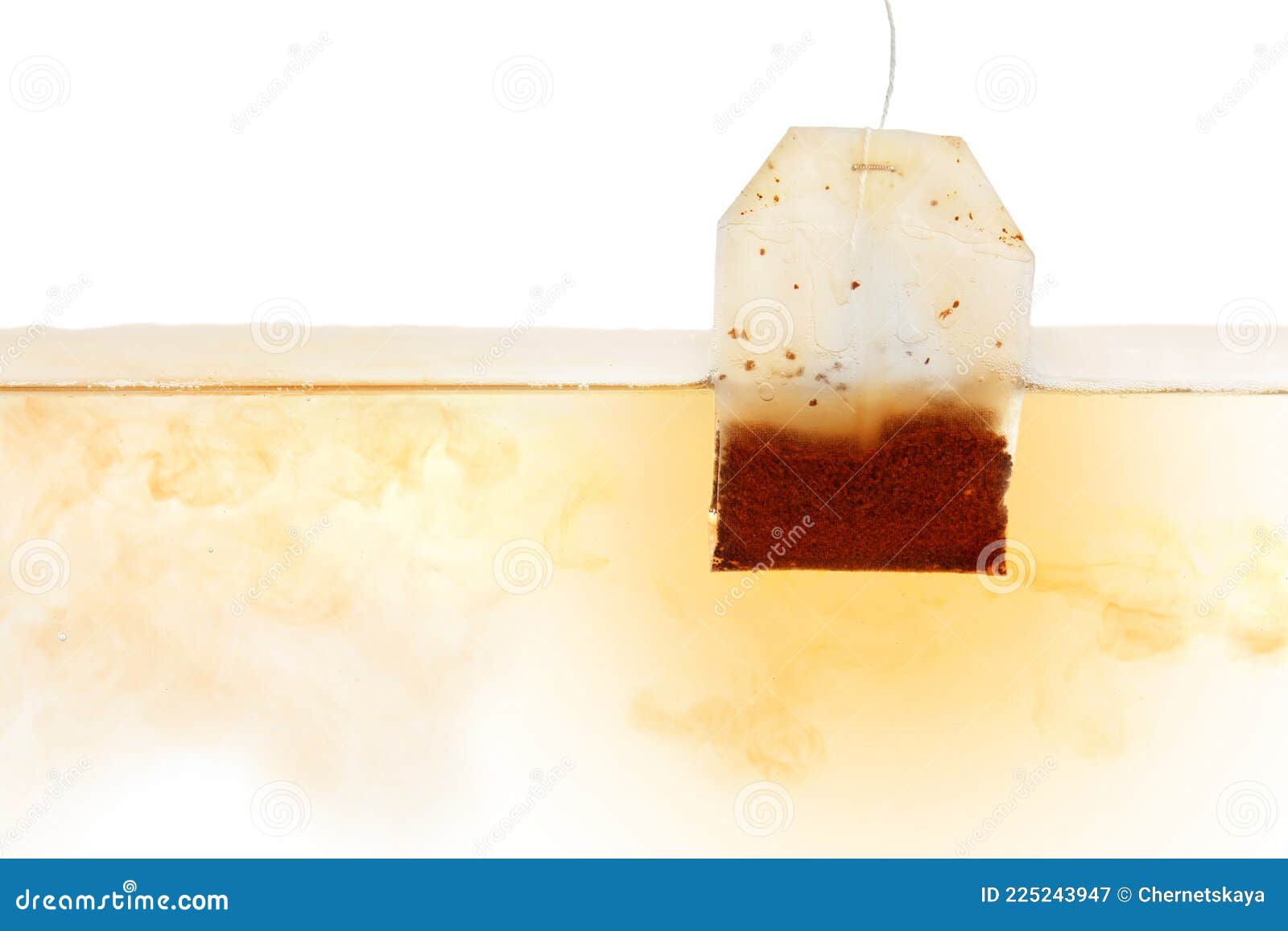 Dipping of Tea Bag into Hot Water Against White Background Stock Image