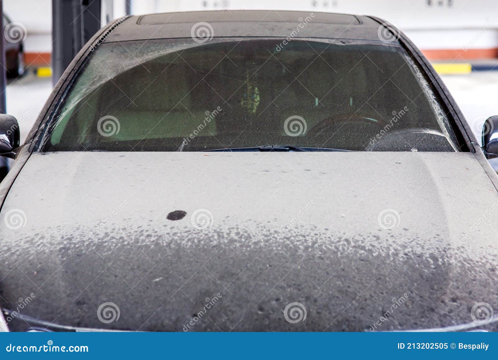 dirty black car with wiped windshield wipers.