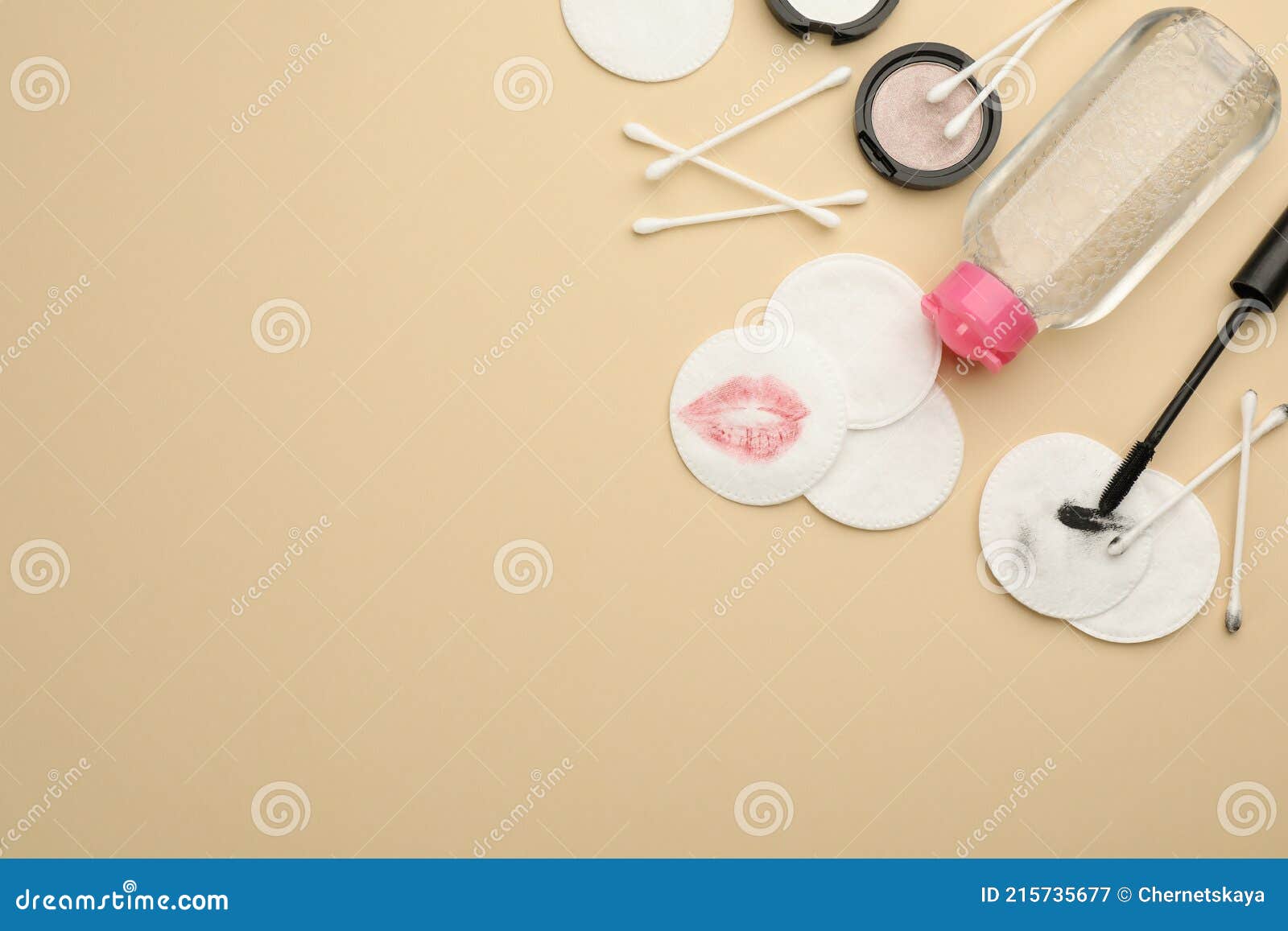 dirty cotton pads, swabs, cosmetic products and micellar cleansing water on beige background, flat lay. space for text