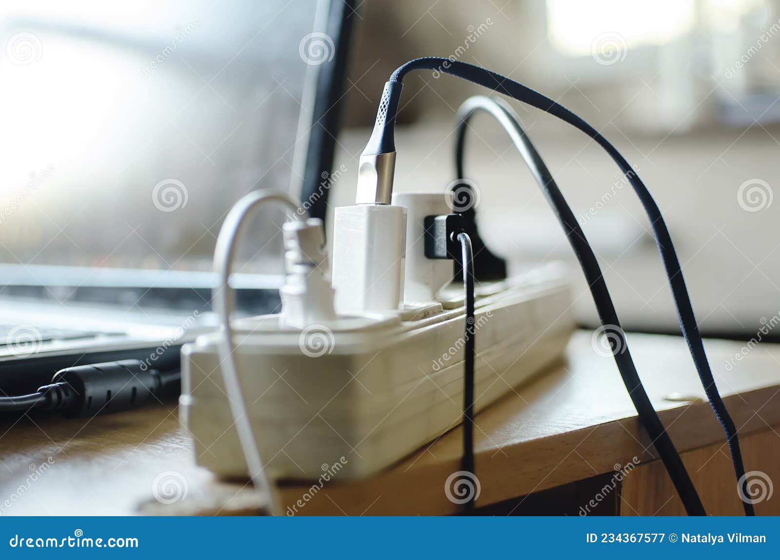 dirty extension socket with various chargers and devices connected