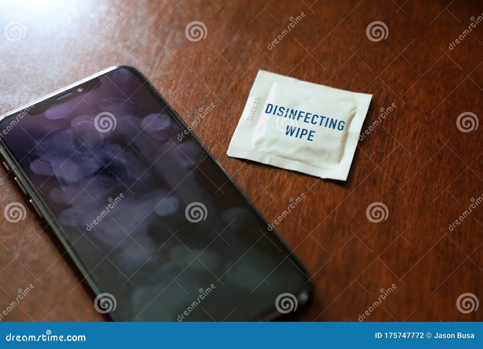 Dirty and Germ Covered Smart Phone with Disinfecting Wipe Stock Photo