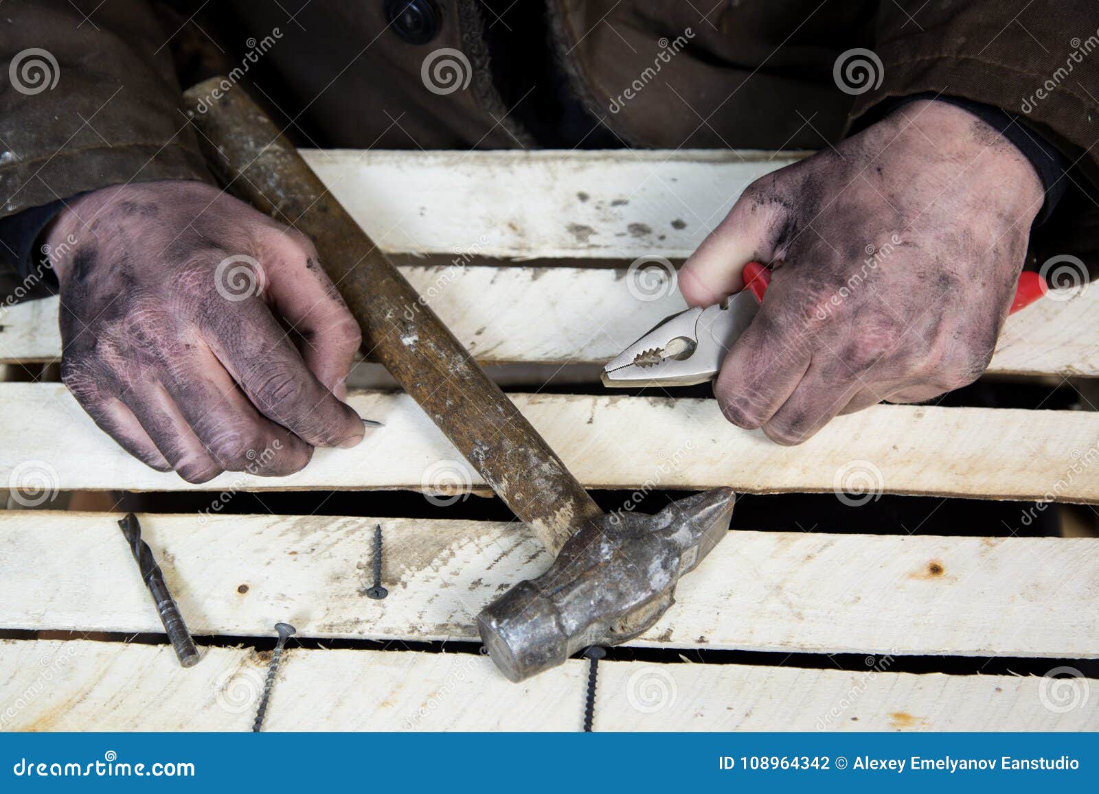 Dirty Hands of Workers with Tools Hammers and Nails. Stock Photo