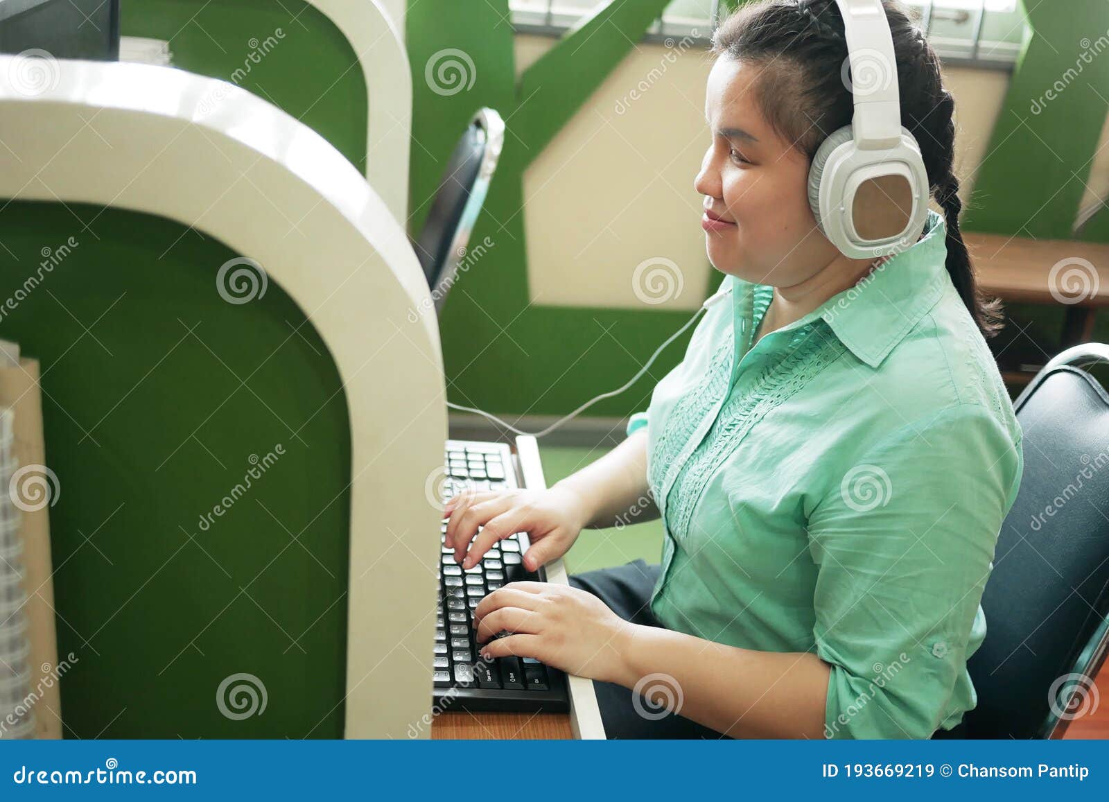 disability young blind person happy woman in headphone typing on computer keyboard working in creative workplace office