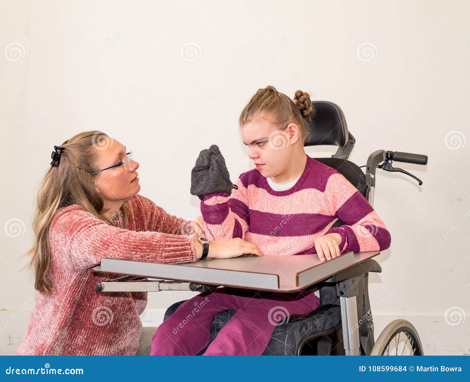 a disabled child in a wheelchair together with a voluntary care worker