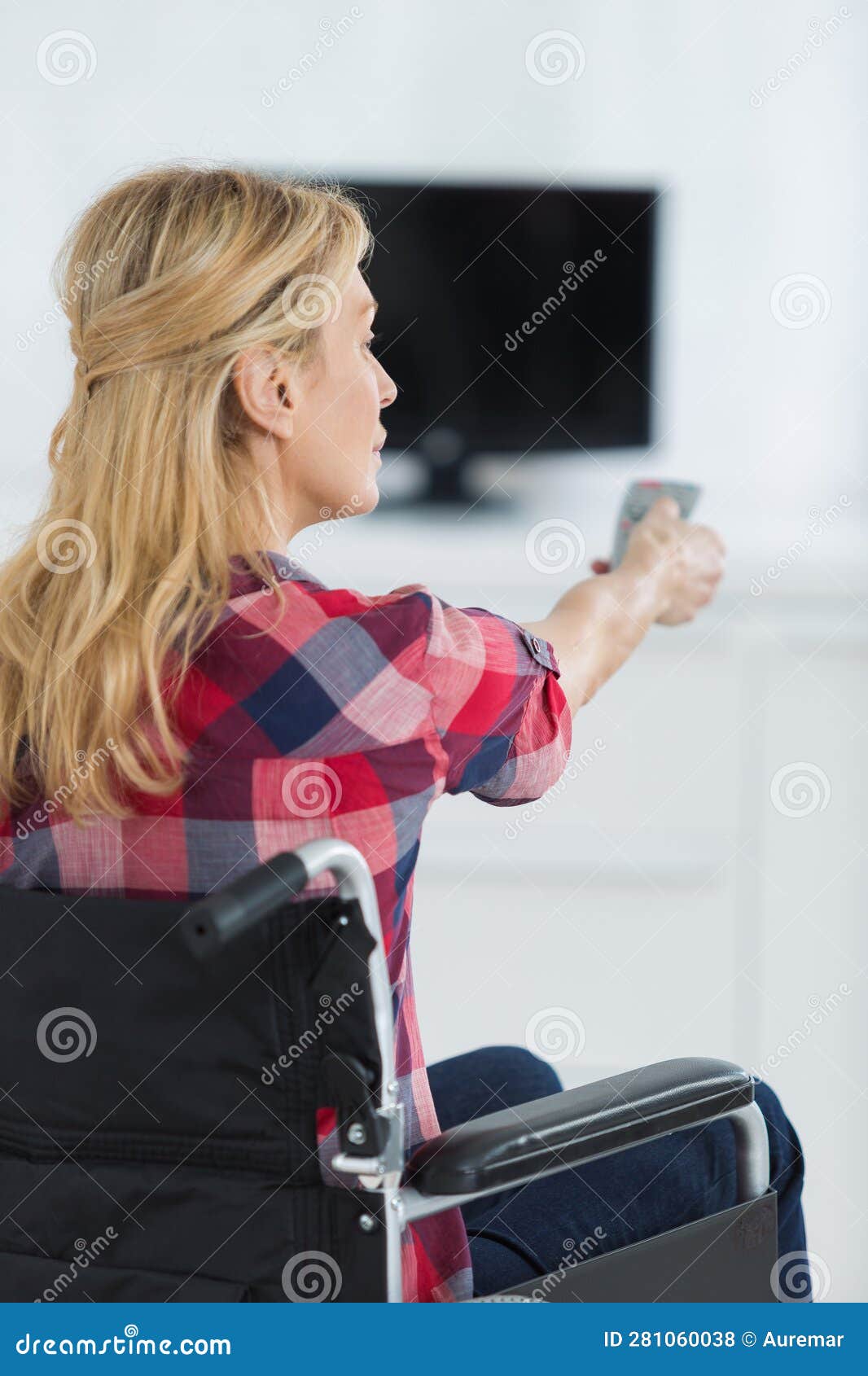 Disabled Lady Changing TV Channel with Remote Control Stock Photo