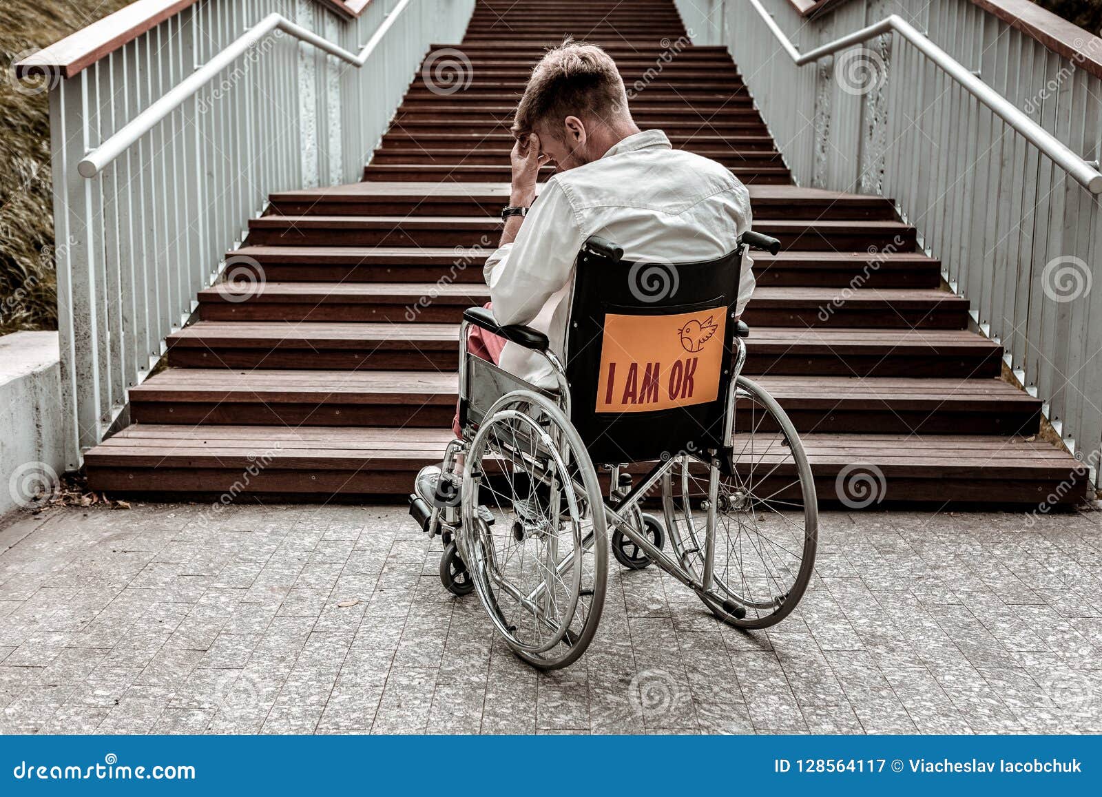 Disabled Man Sitting in Wheelchair in Front of the Stairs Stock Image