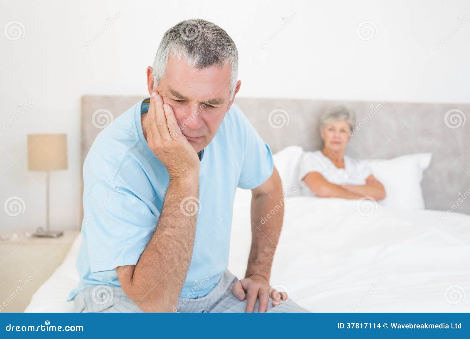 disappointed senior man with woman in background