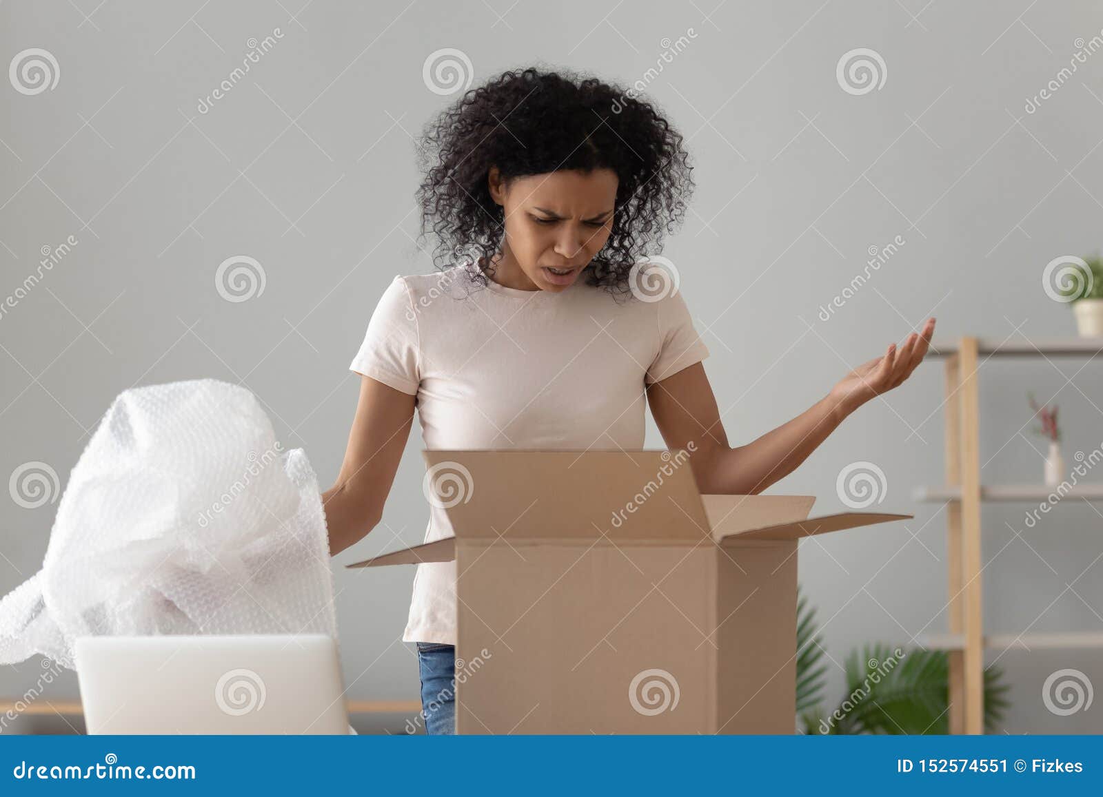 disappointed shocked african woman open cardboard box receive bad parcel