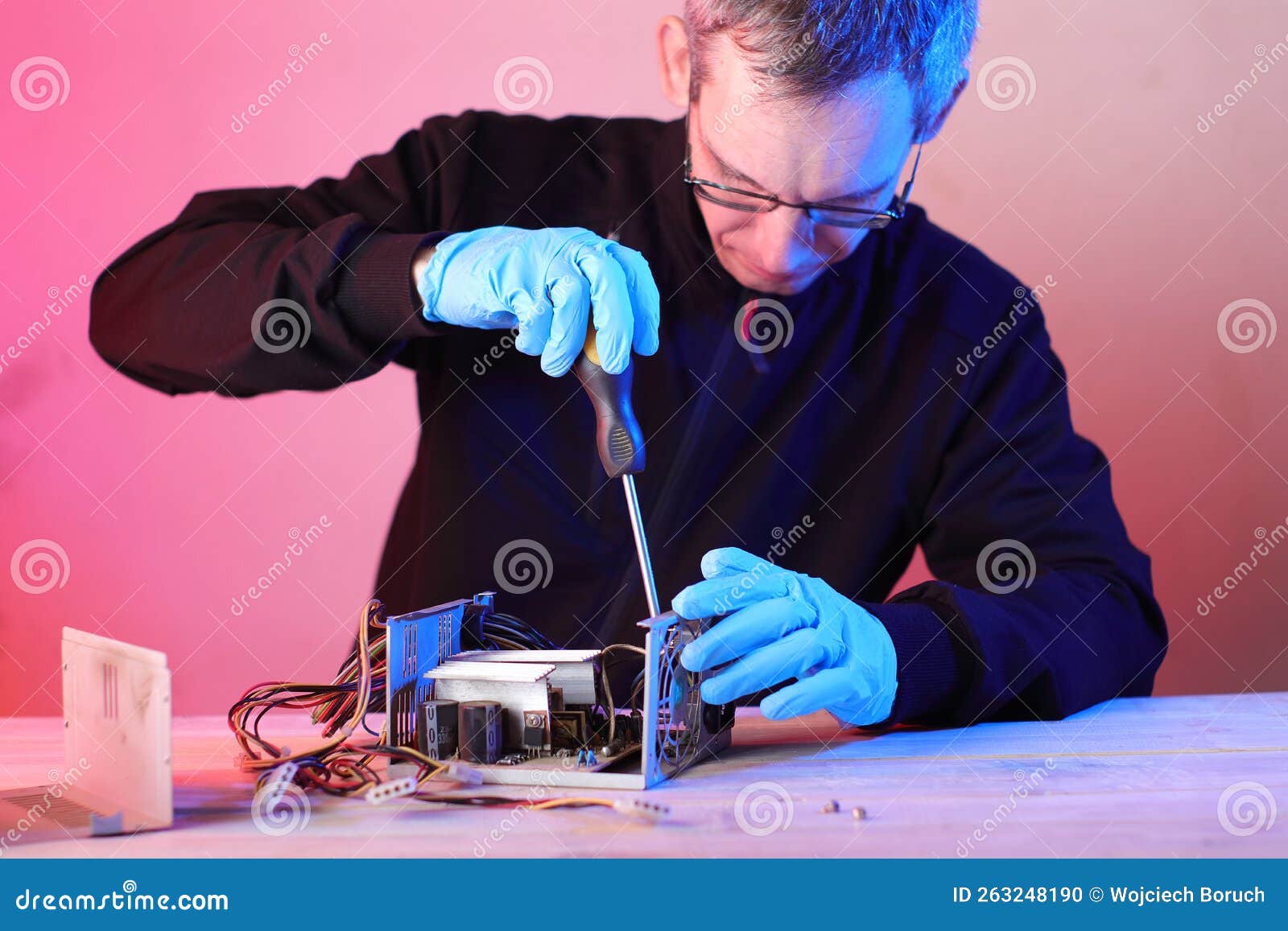Disassembly of a Computer Power Supply on a Table by a Person Stock