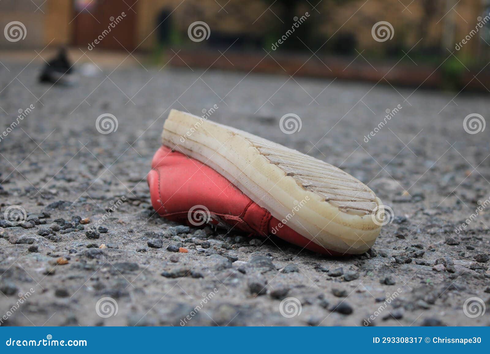 discarded children's pink shoe upside down in a public space