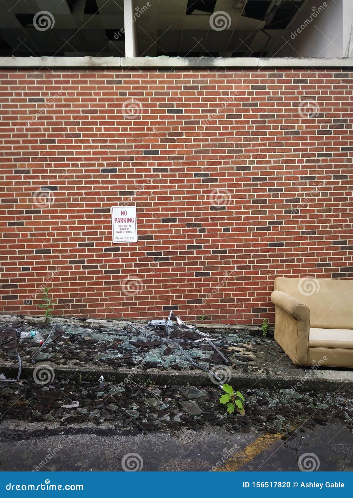abandoned couch and red brick wall exterior of abandoned building background.