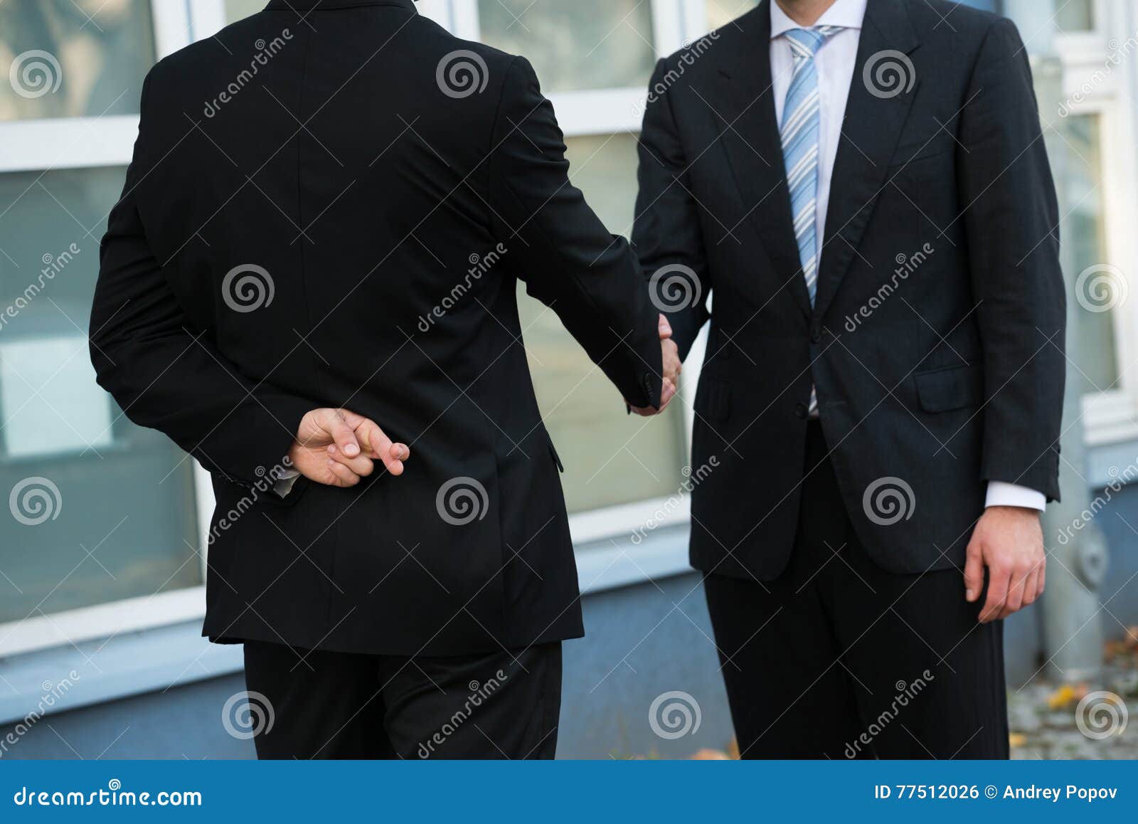 dishonest businessman shaking hands with partner