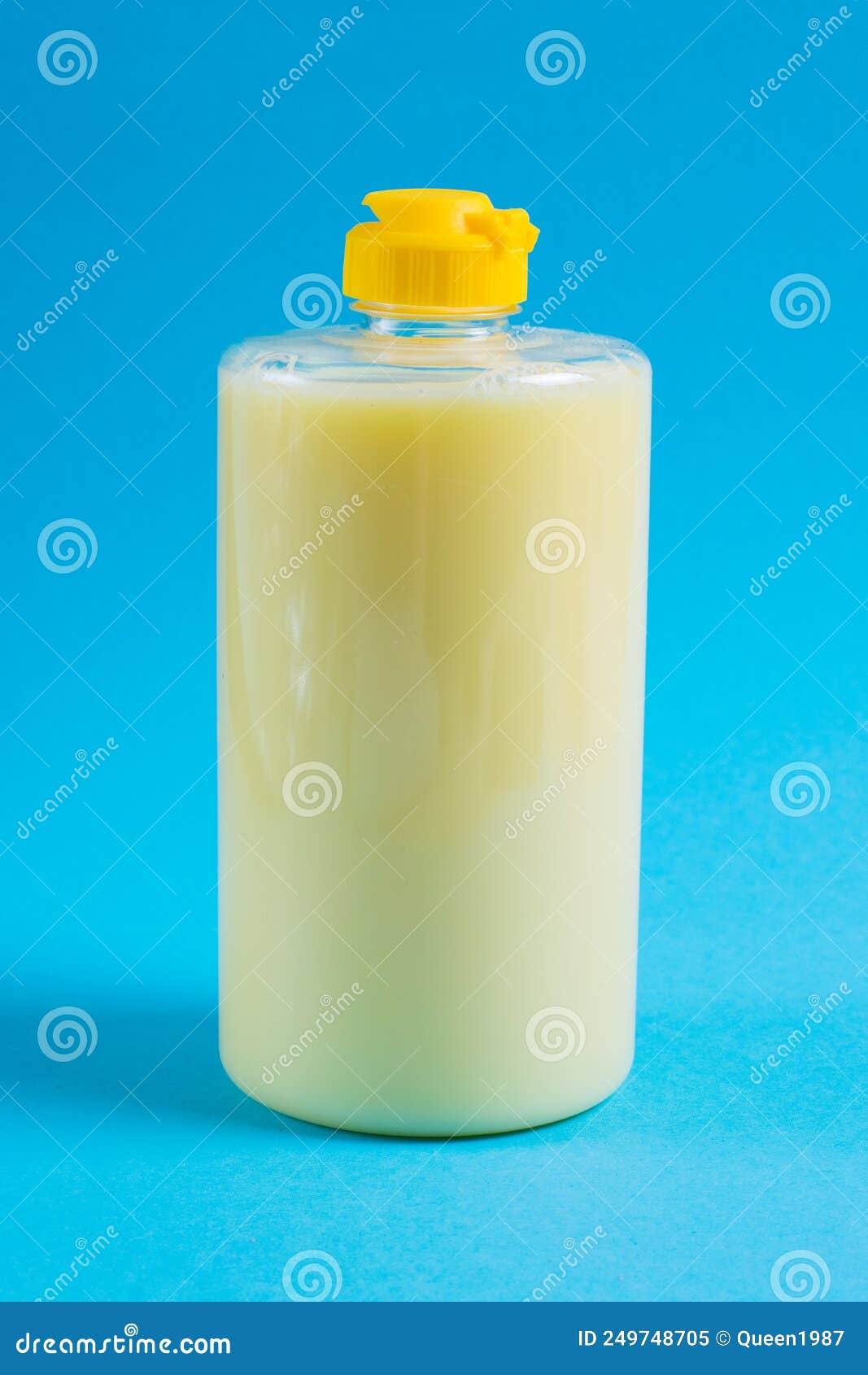 Dishwashing Liquid in a Transparent Plastic Package on a Blue Background. the Concept of