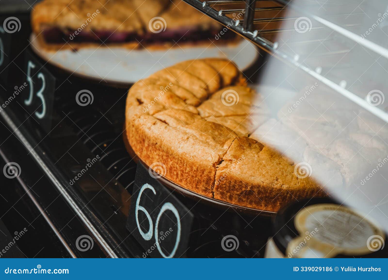 display case with a variety of cakes and cupcakes. deserts at cafes and coffeeshops. chicken pie front view close up.
