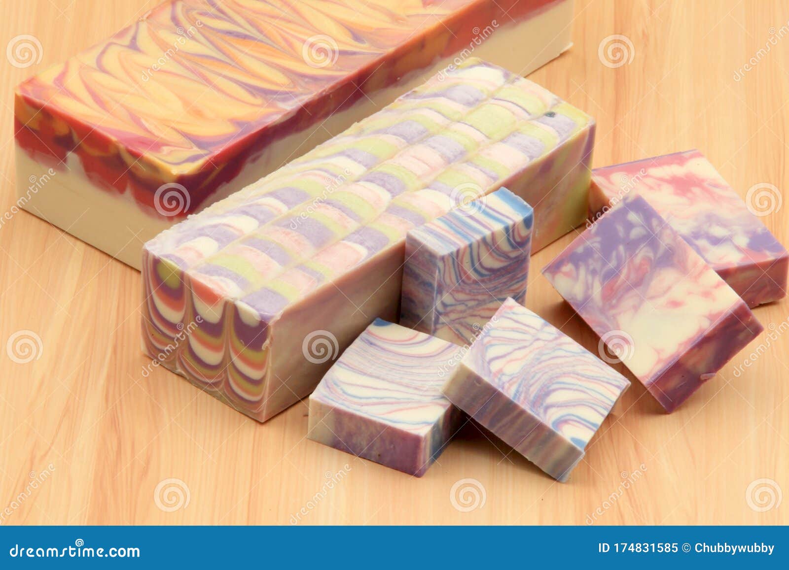 display of handcrafted soap blocks and bars on a wooden backdrop