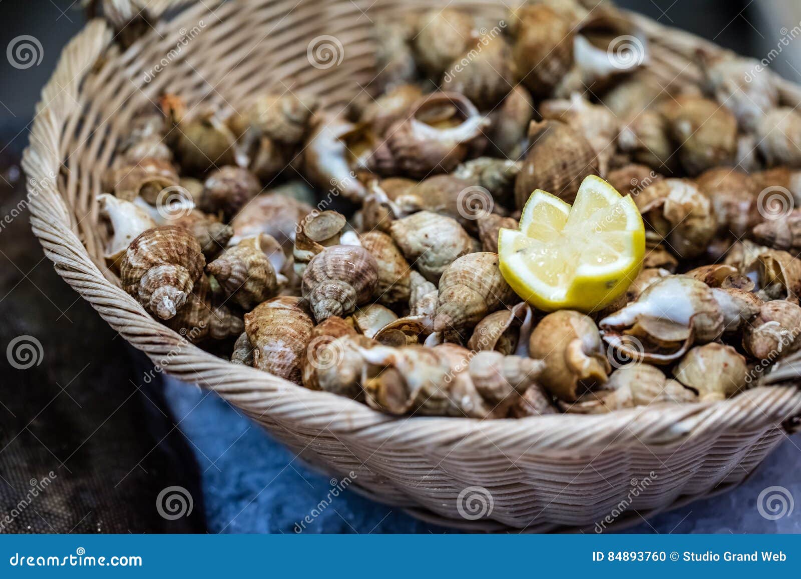 display of small whelks or french bulots crustaceans in basket