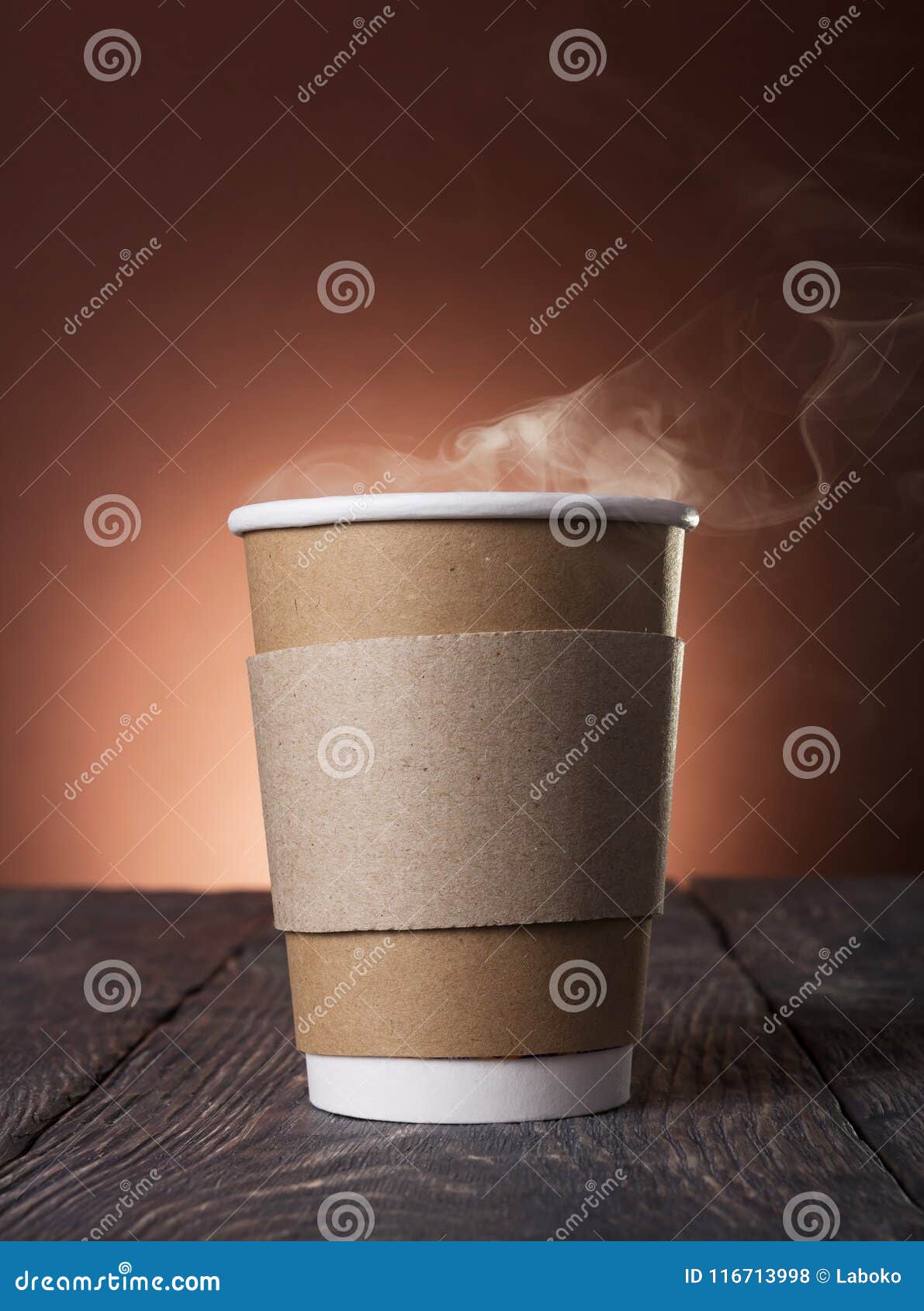 disposable cup of steaming hot coffee on wooden table