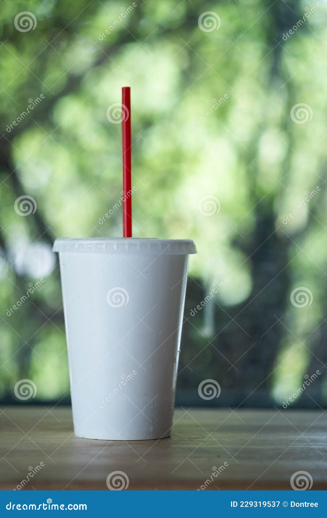 The Disposable Cup of Volume for Beverages with Red Straw Stock Image