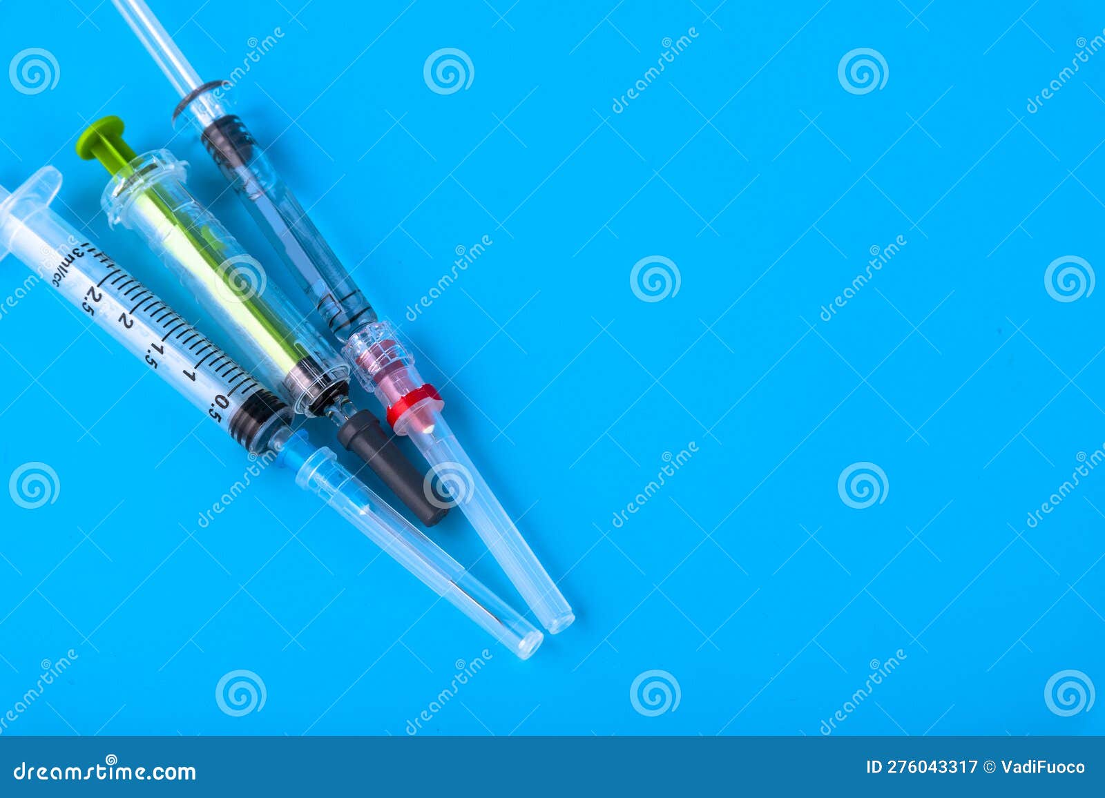 Disposable Medical Hypodermic Syringes on a Blue Background. Copy Space