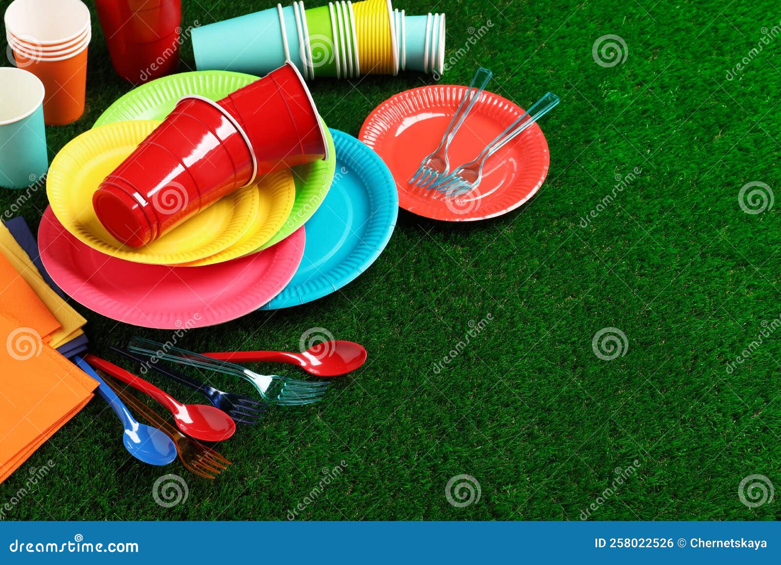 Disposable Tableware on Green Artificial Grass. Space for Text Stock