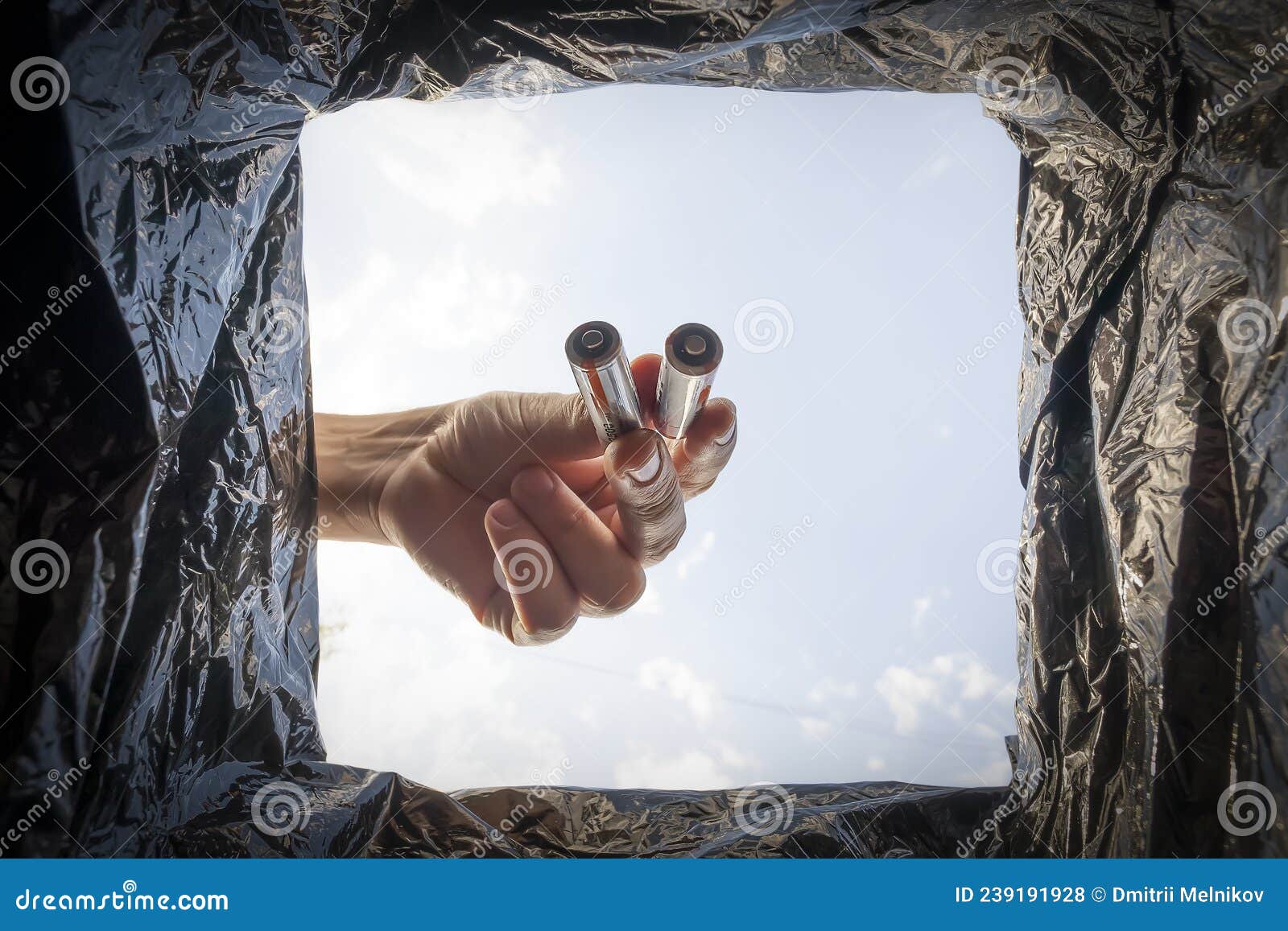 Disposal of Batteries. Man Puts Old Used AA Batteries in a Trash Can