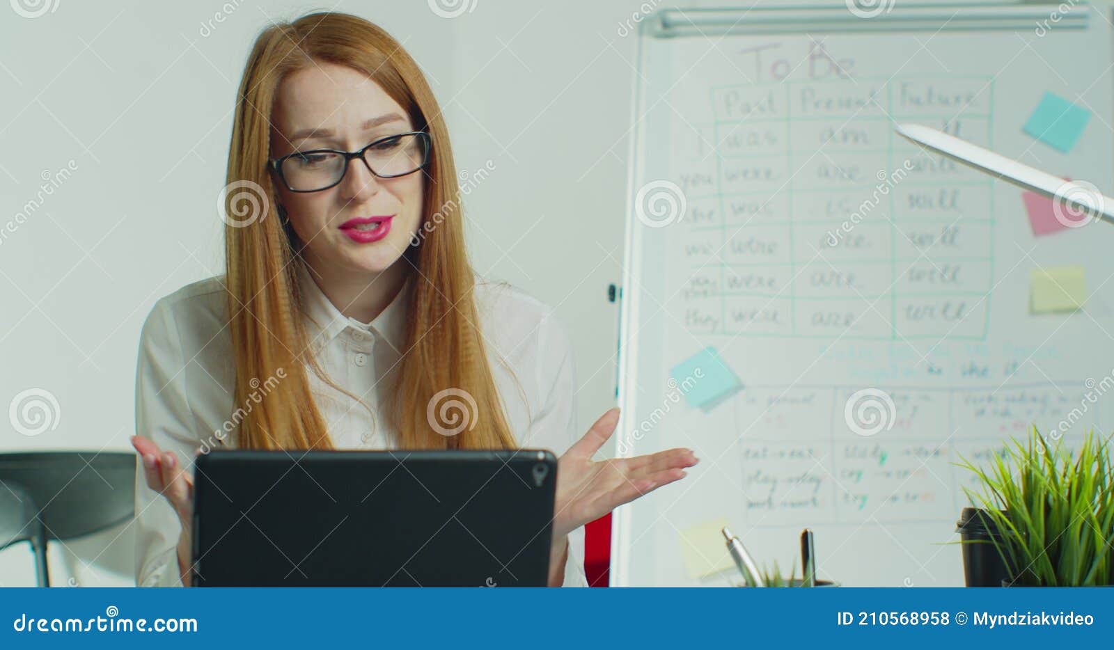 distance learning for schoolchildren, a young modern teacher leads online lessons for students using a tabletpc during