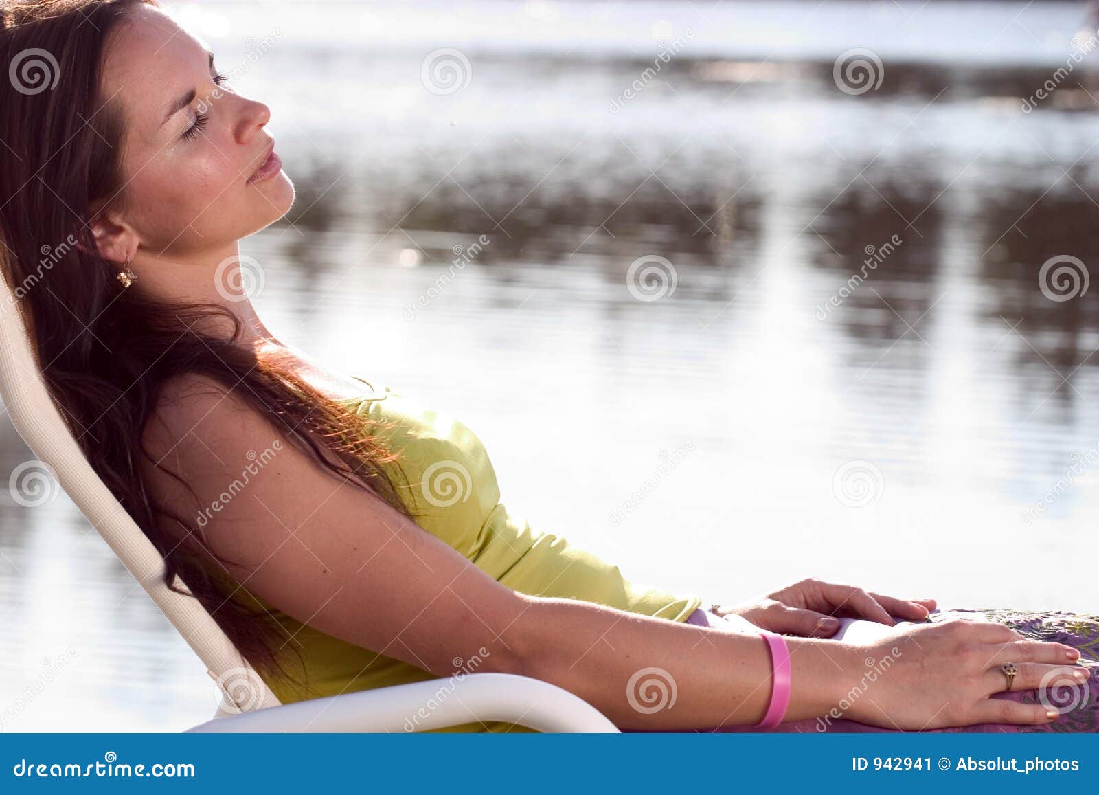 Distensione del Brunette. Brunette attraente che si distende su un deckchair.