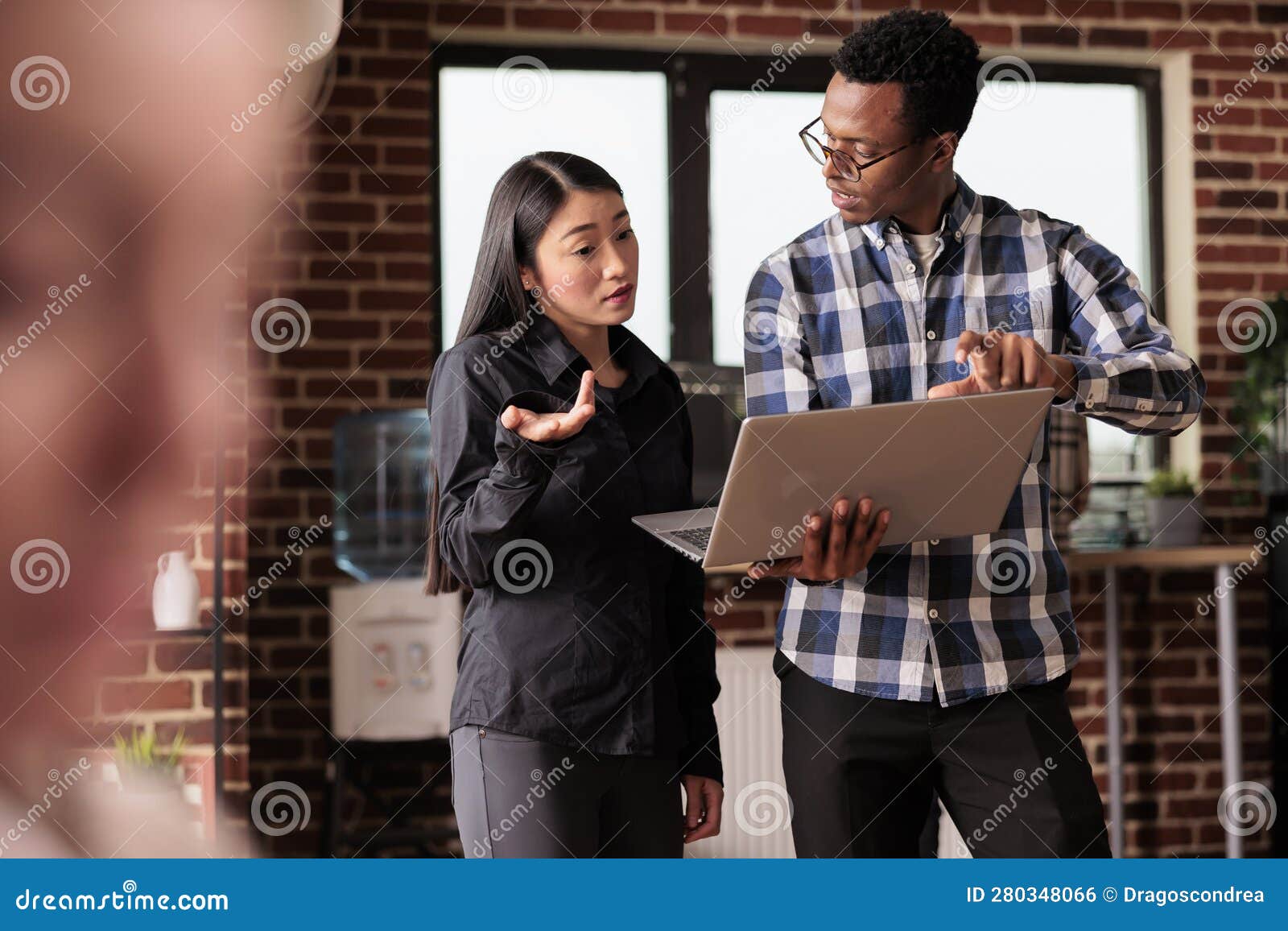 diverse coders looking at security firewall on laptop