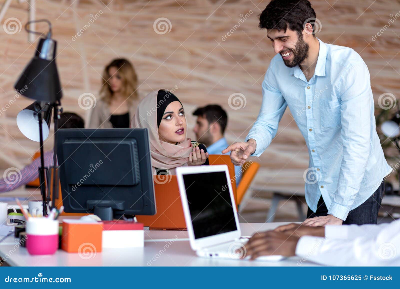 Diverse College Students Using Laptop and Talking, Learning Exchanging