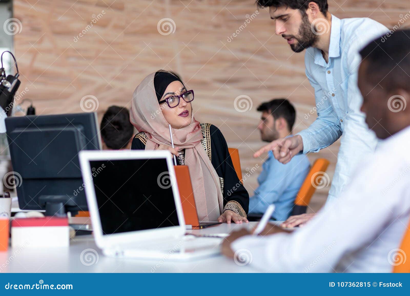 Diverse College Students Using Laptop and Talking, Learning Exchanging