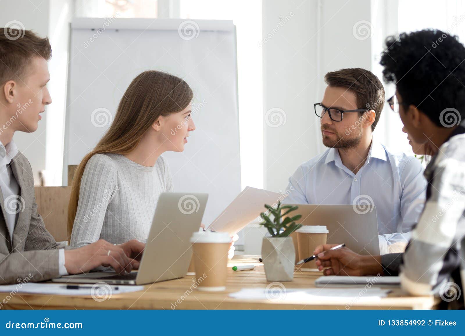 Diverse Employees Sit at Meeting Collaborating in Office Stock Photo