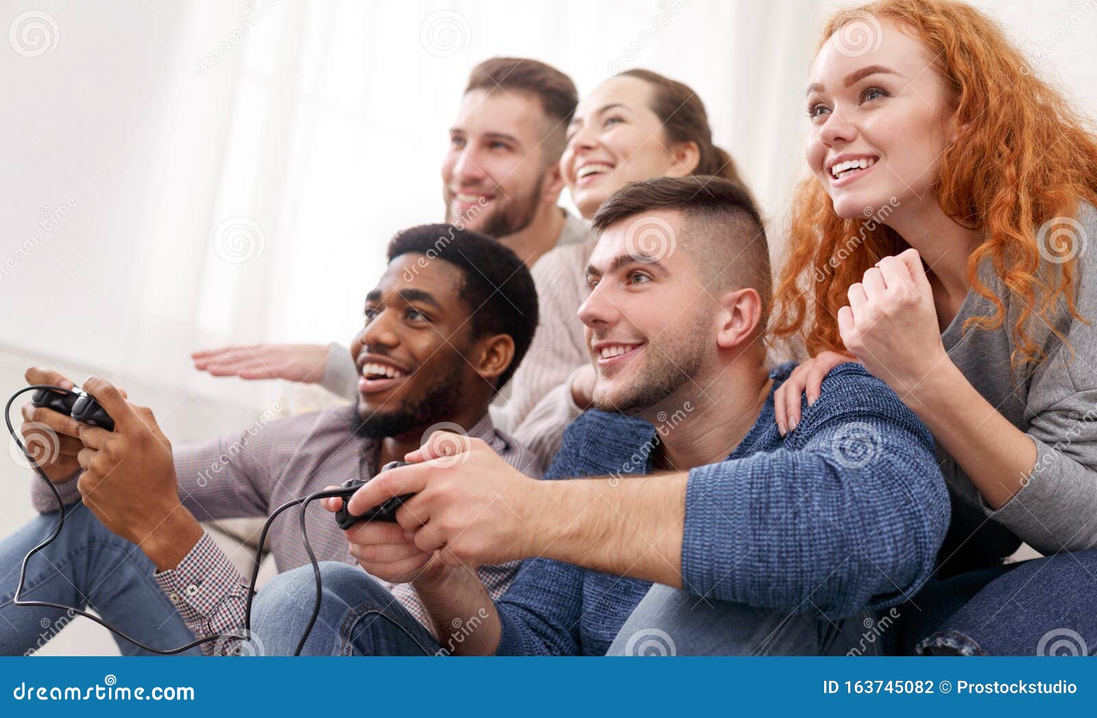 Group of diverse friends playing game on mobile phone Stock Photo