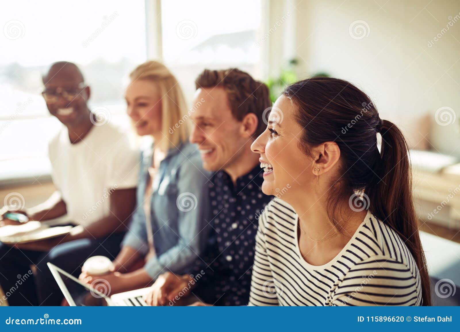 diverse businesspeople laughing together during an office presen