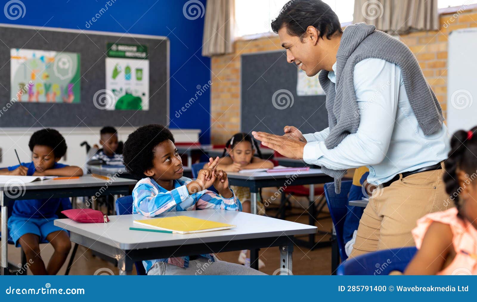 Diverse Male Teacher Teaching School Boy Using Sign Language in Class