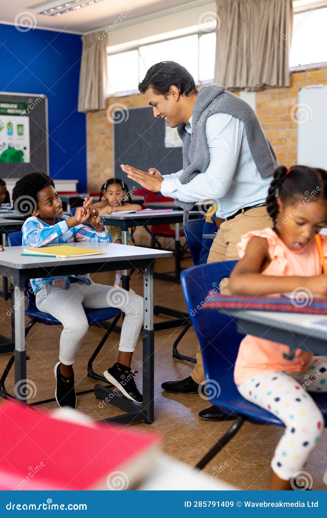 Diverse Male Teacher Teaching School Boy Using Sign Language in Class