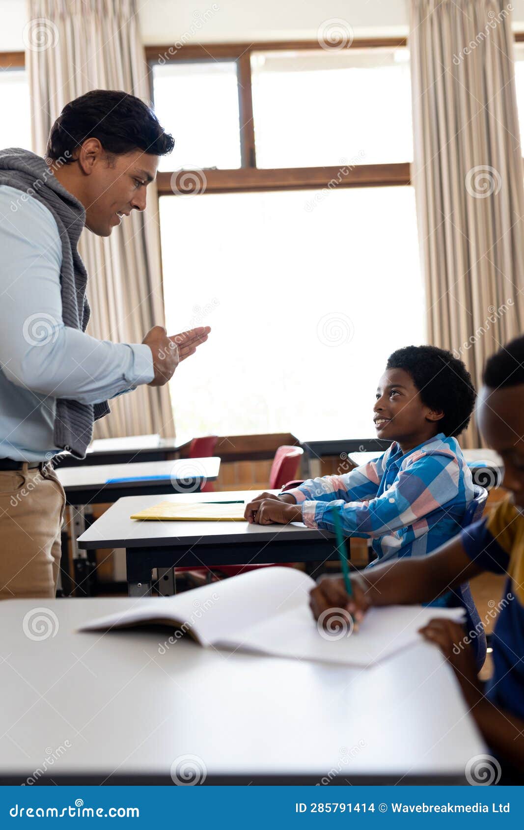 Diverse Male Teacher Teaching School Boy Using Sign Language in Class