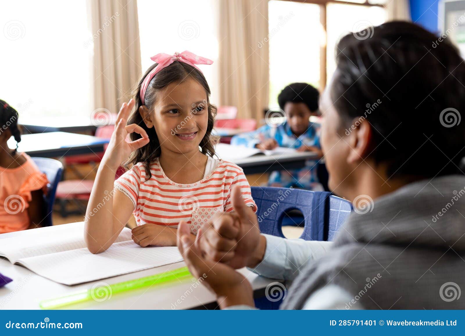 Diverse Male Teacher Teaching School Girl Using Sign Language in Class