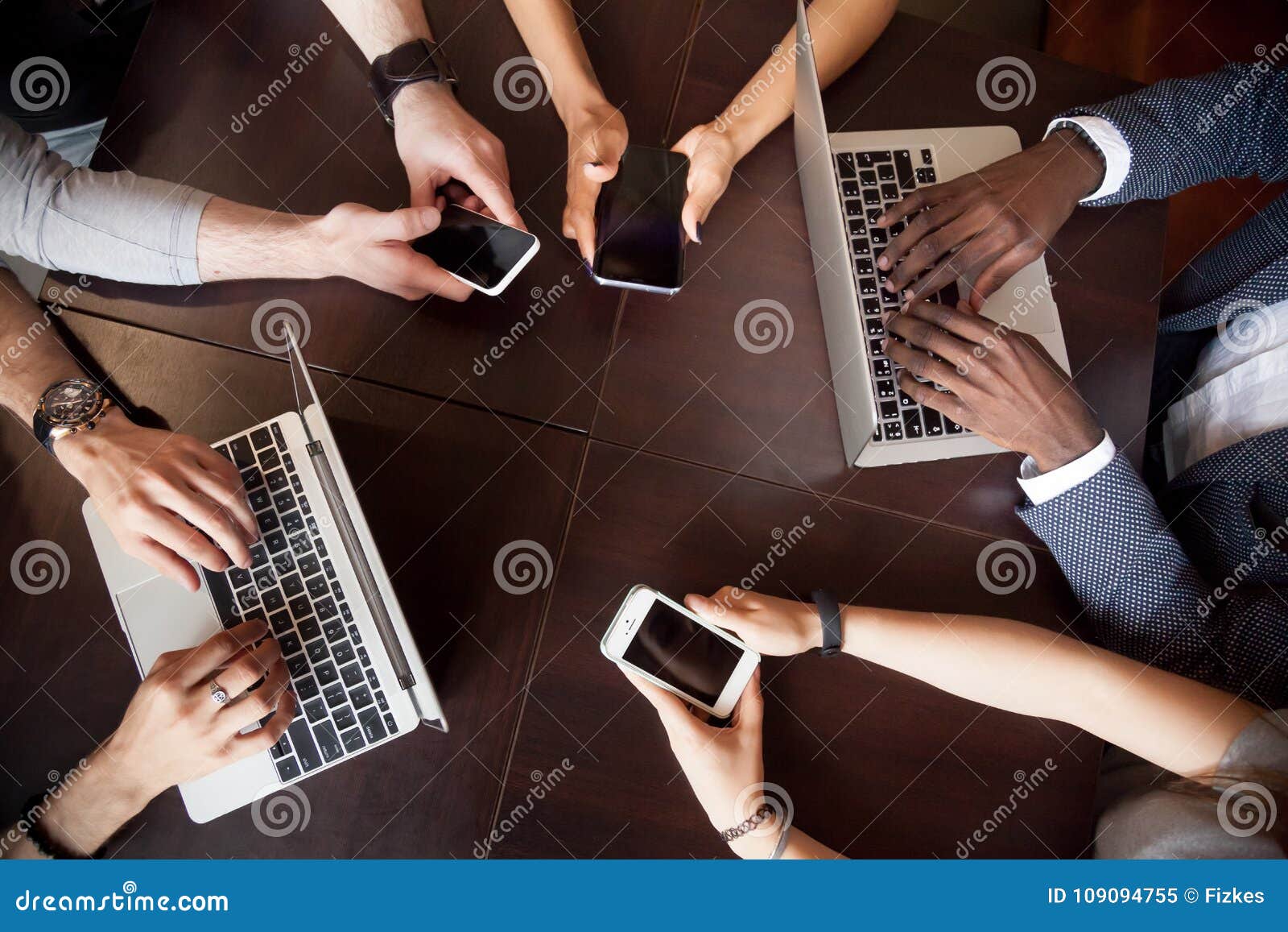 diverse multiracial people using laptops smartphones on table, t