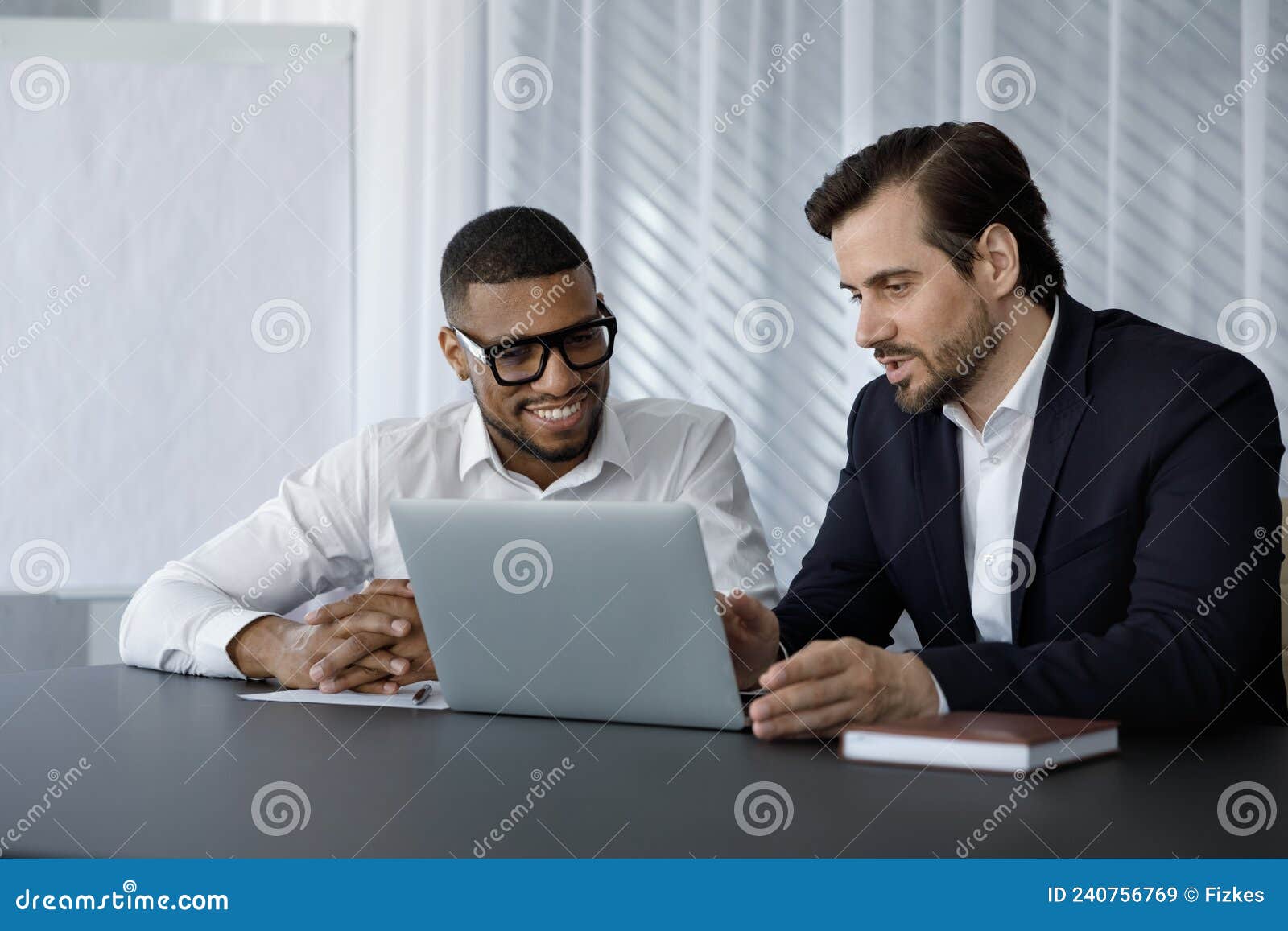 diverse office employees in formalwear of using laptop computer together