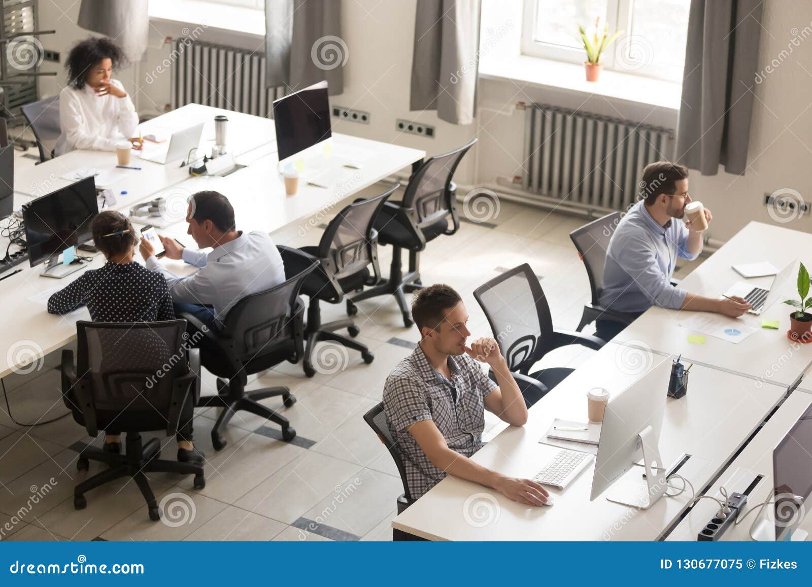 diverse office workers using computers in modern corporate space