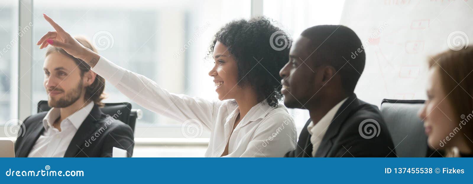 african woman raise hand ask question during seminar at boardroom