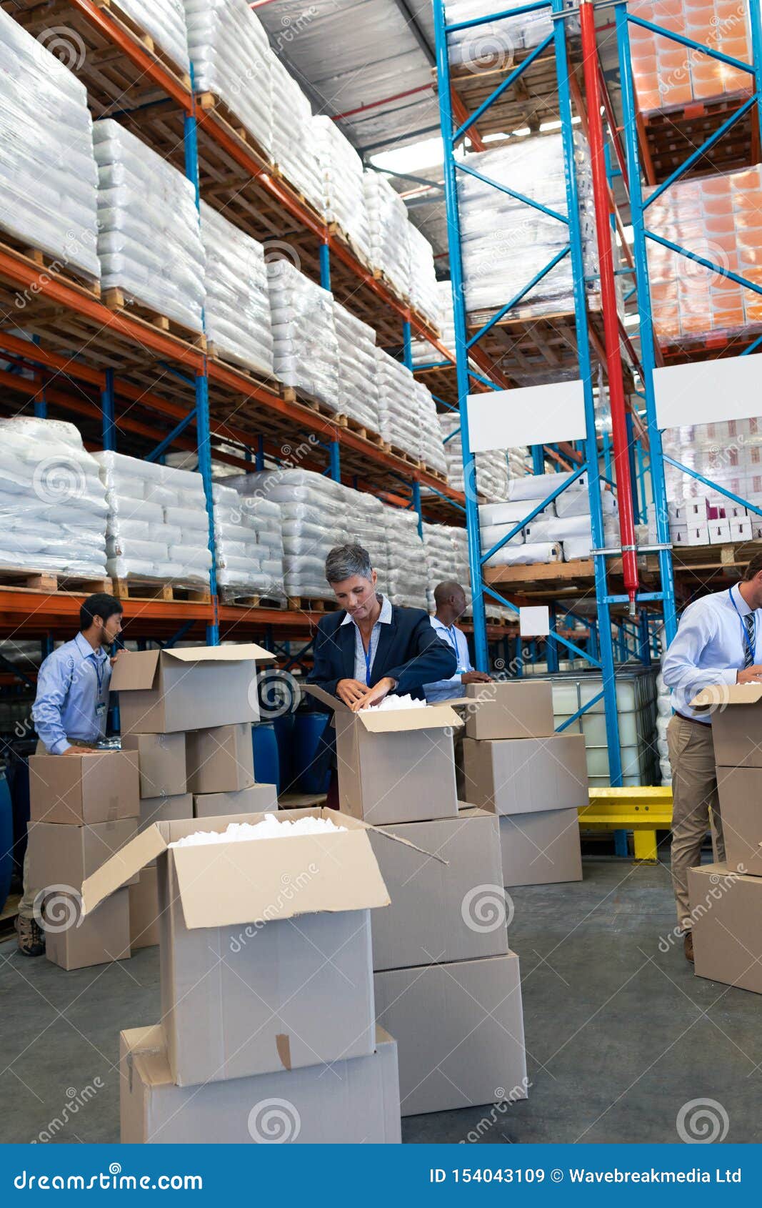 Diverse Staff Unpacking Cardboard Boxes in Warehouse Stock Image