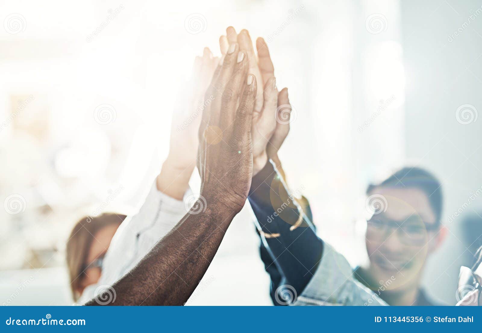 diverse team of businesspeople high fiving together in an office
