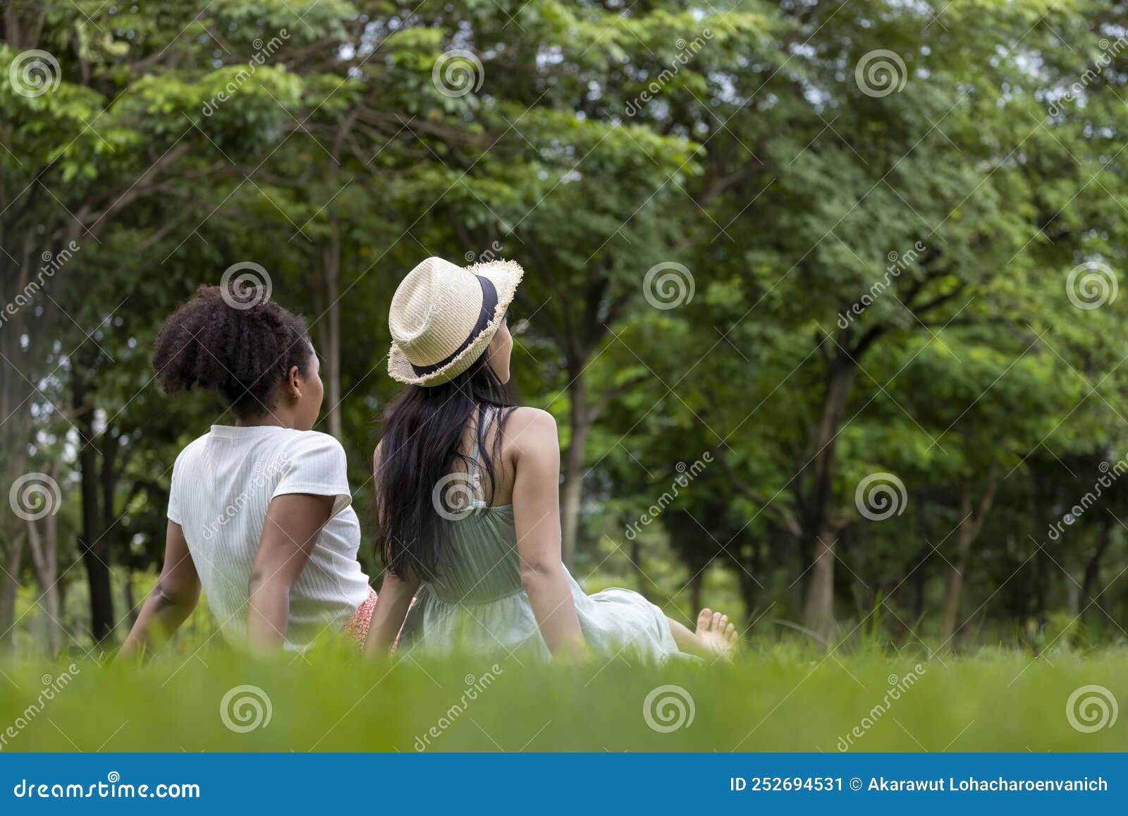 Diversity Of Lgbtq Lesbian Couple Is Relaxingly Sitting Together On The Grass Lawn In Public