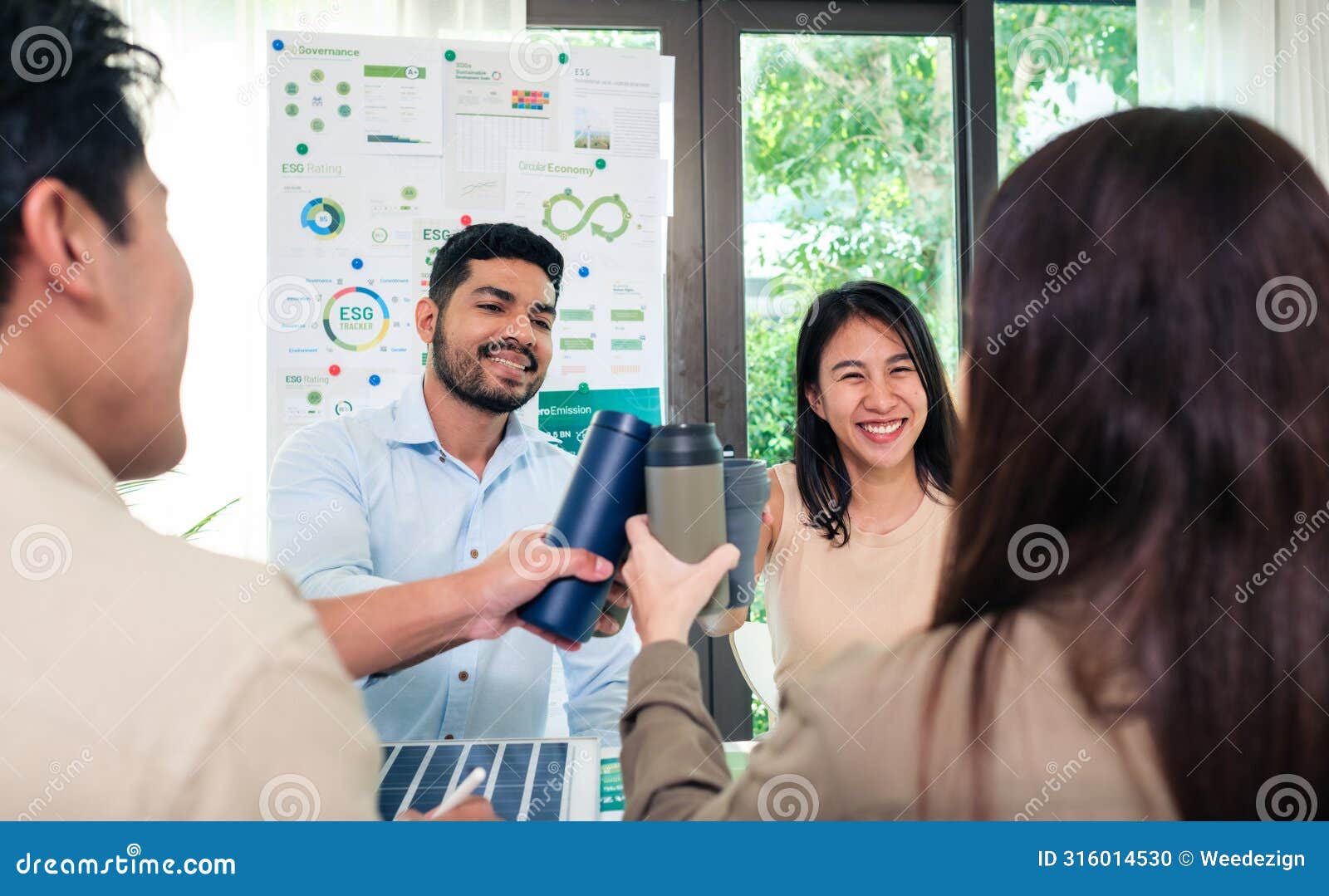 diversity team toasting celebration with reusable bottle of sustainability goals is success at green environment office