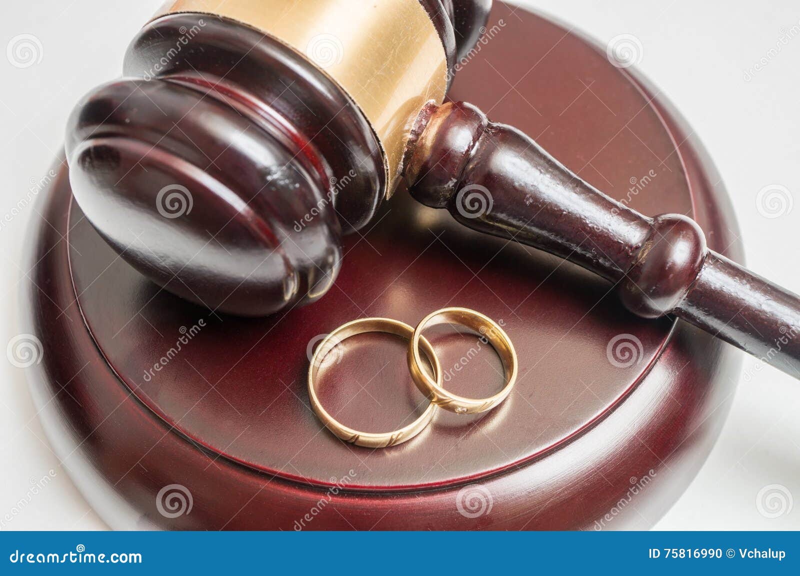 Divorce Concept. Closeup View on Gavel and Wedding Rings Stock Photo